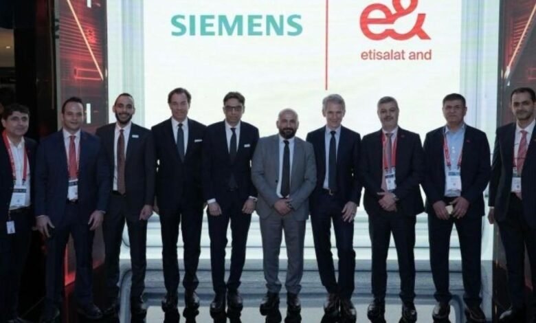 Group of men in suits standing in front of Siemens and Etisalat logos.