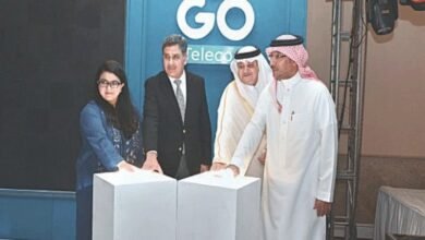 Four individuals stand behind white pedestals with the GO Telecom logo in the background.