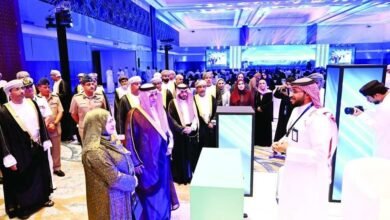 Attendees in traditional attire at a formal event with modern displays.