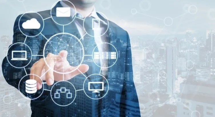 Businessman interacting with a digital network of cloud, database, and communication icons.