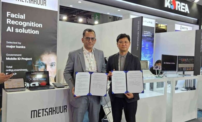 Two men in suits hold signed documents at a technology exhibition booth.