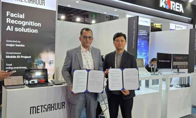 Two men in suits hold signed documents at a technology exhibition booth.