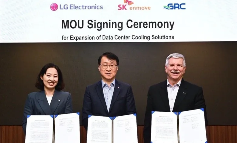 Three individuals smiling and holding signed documents at an MOU signing ceremony.