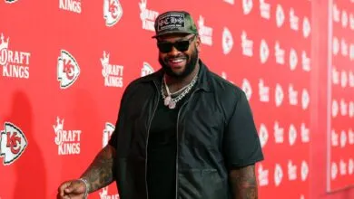 NFL player Chris Jones smiles on a red carpet with DraftKings and Kansas City Chiefs logos.