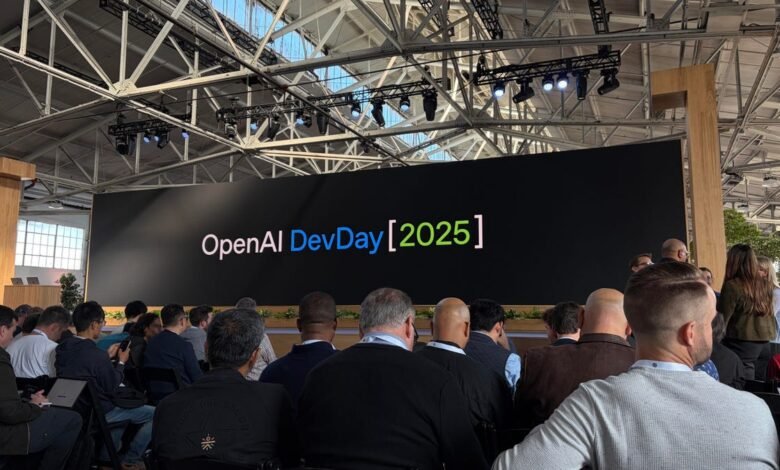 Audience watches a large screen displaying "OpenAI DevDay [2025]" at a conference.