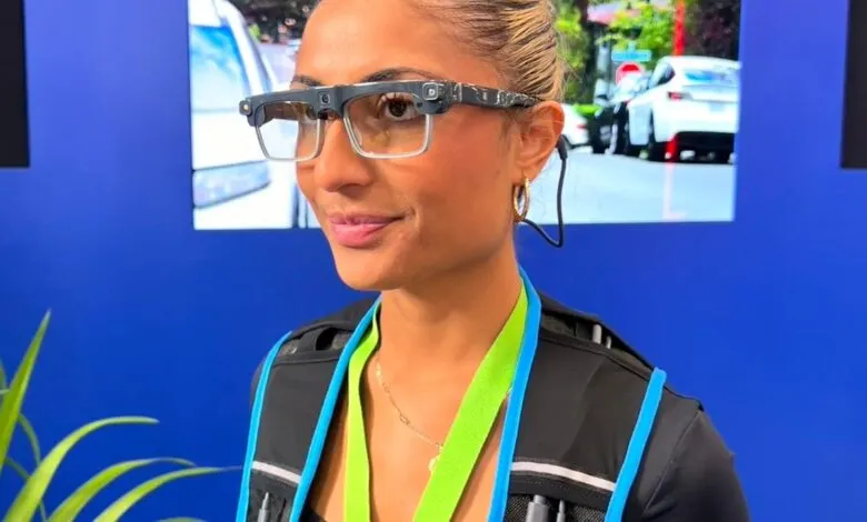 Woman wearing smart glasses and a vest with bright blue and green accents