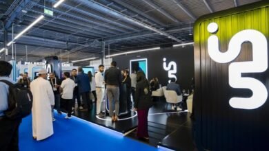 People networking at a modern exhibition booth with a large white 'in.' logo on a black background.