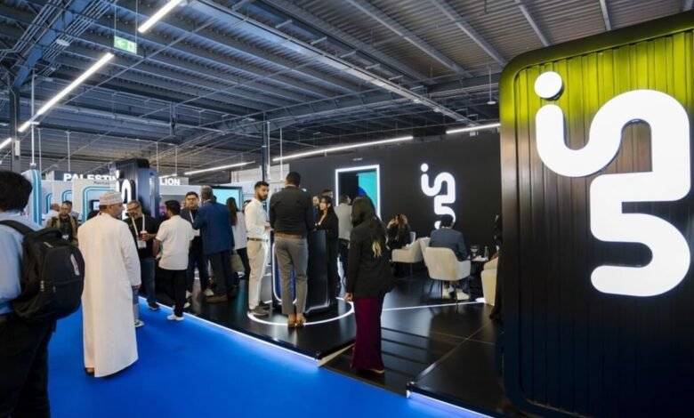 People networking at a modern exhibition booth with a large white 'in.' logo on a black background.