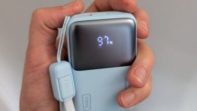 Hand holding a light blue power bank displaying 97% battery charge.