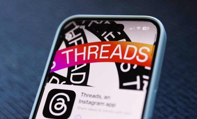 Close-up of a smartphone screen displaying the Threads app logo and name.