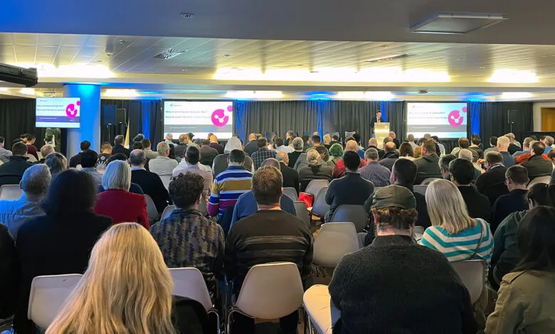 Audience listens to a speaker at a conference about AI Cyber War.
