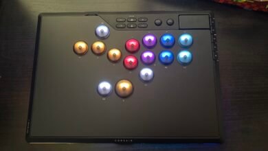 Close-up of a black Corsair fight stick with illuminated buttons in red, gold, blue, and purple.