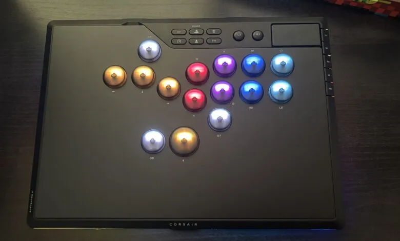 Close-up of a black Corsair fight stick with illuminated buttons in red, gold, blue, and purple.