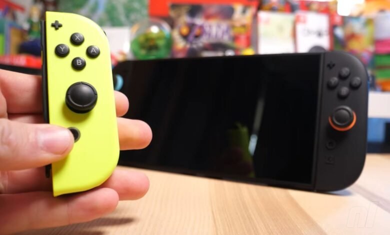 A hand holds a neon yellow Nintendo Switch Joy-Con controller next to the console.