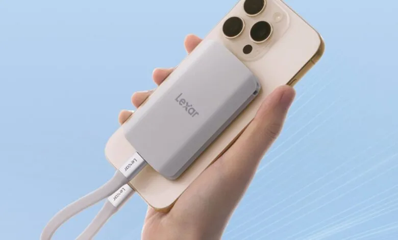 Hand holding a smartphone with a Lexar portable SSD attached.