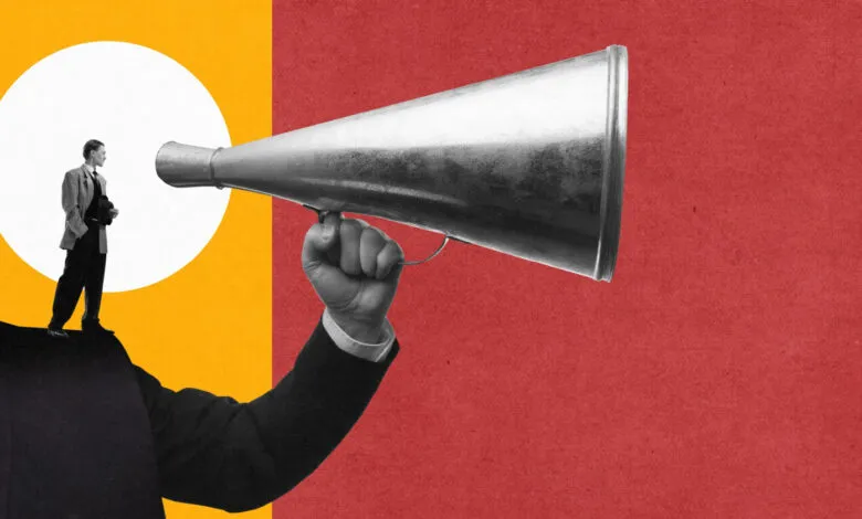 Man in suit standing on a shoulder holding a megaphone against a red and yellow background.