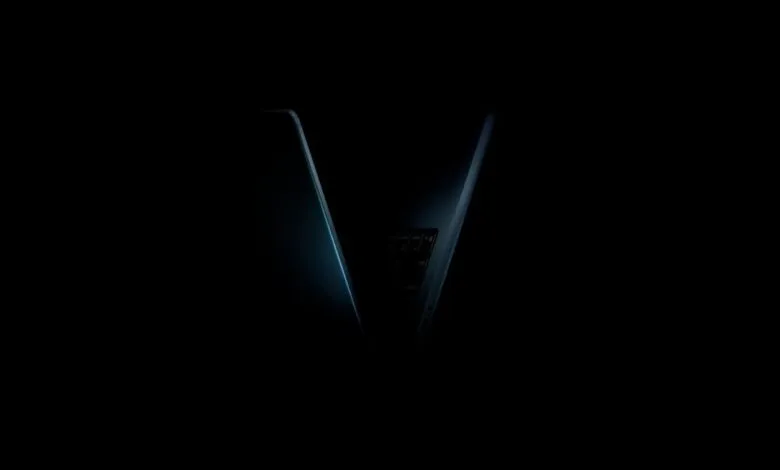 Close-up of a sleek, dark laptop with illuminated keyboard keys in a dark setting.