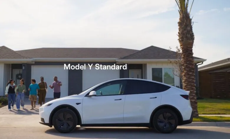 A white Tesla Model Y parked in front of a suburban house with a family walking towards it.