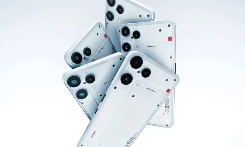 Multiple white Nothing Phone devices with visible camera lenses and unique design elements.