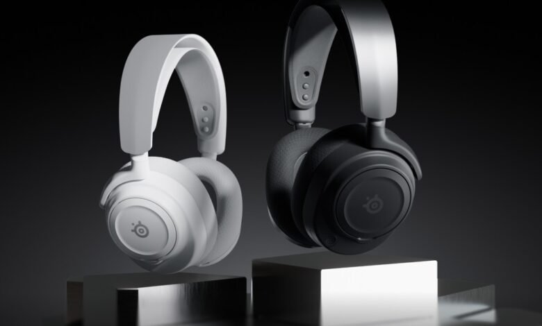 Two SteelSeries gaming headphones, one white and one black, displayed on metallic stands.