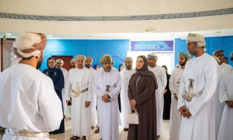 Group of Omani men and women in traditional attire gathered indoors.