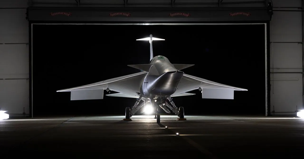 Futuristic aircraft with delta wings parked inside a hangar at night.