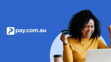Woman celebrating while holding a credit card and looking at a laptop.
