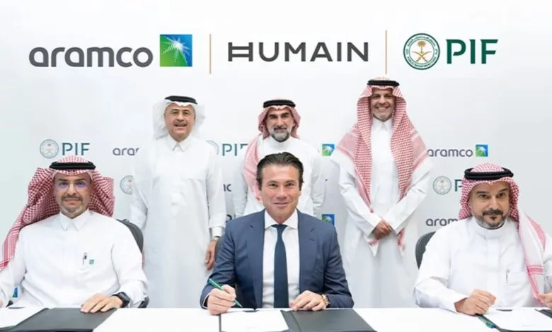 Five men in formal attire posing for a photo at a signing ceremony with company logos.