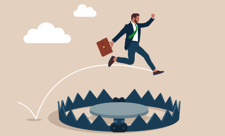 Businessman leaping over a bear trap, symbolizing overcoming business challenges.
