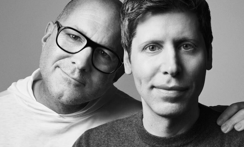 Two men posing for a black and white portrait, one wearing glasses and a hoodie, the other in a sweater.