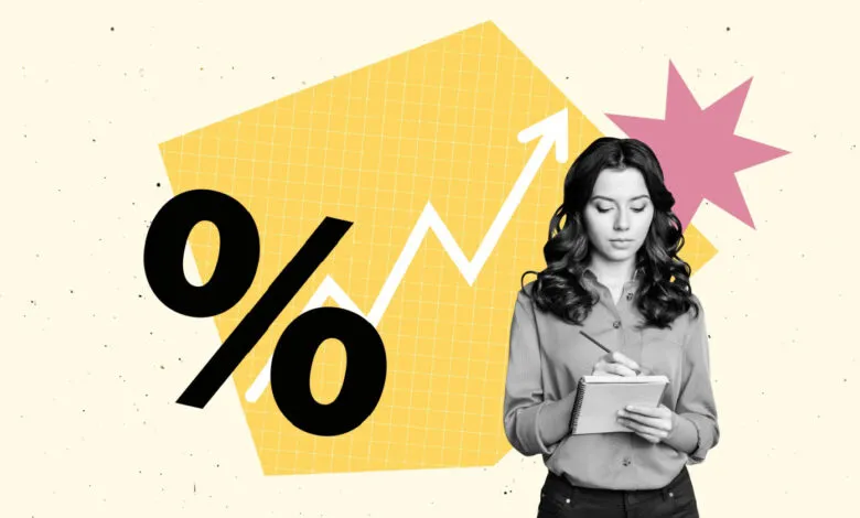Woman writing in notebook with percentage symbol and upward graph