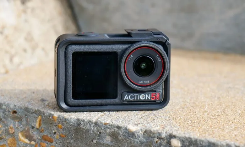 Close-up of a black action camera with a red ring around the lens, labeled ACTION 5 PRO.