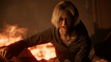 A young woman with glasses cries out in distress amidst flames and smoke.