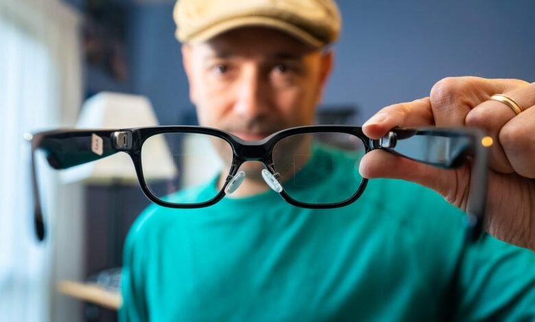 Man holding smart glasses with black frames and clear lenses