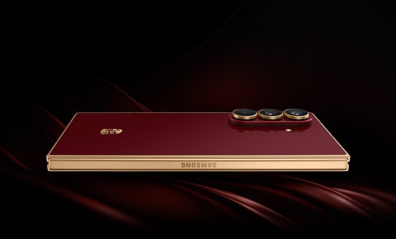 Close-up of a red Samsung W26 flip phone with gold accents and triple camera lenses.