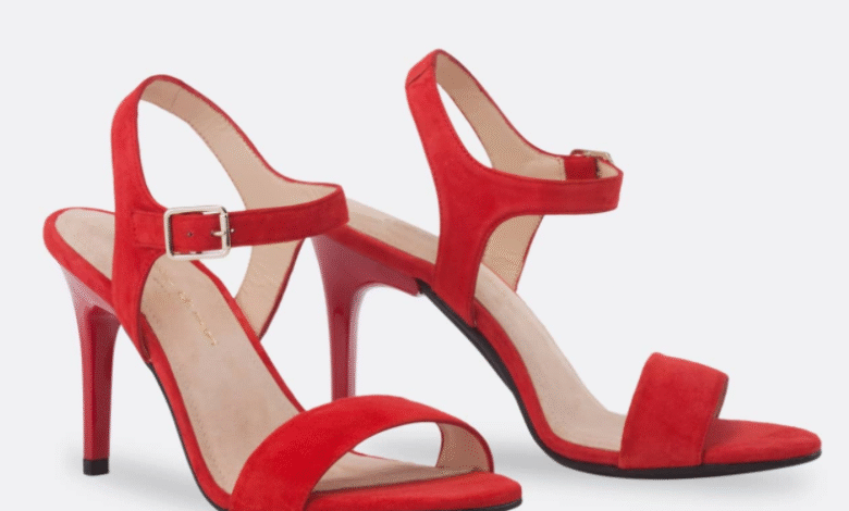 A pair of red suede high-heeled sandals with ankle straps and silver buckles.