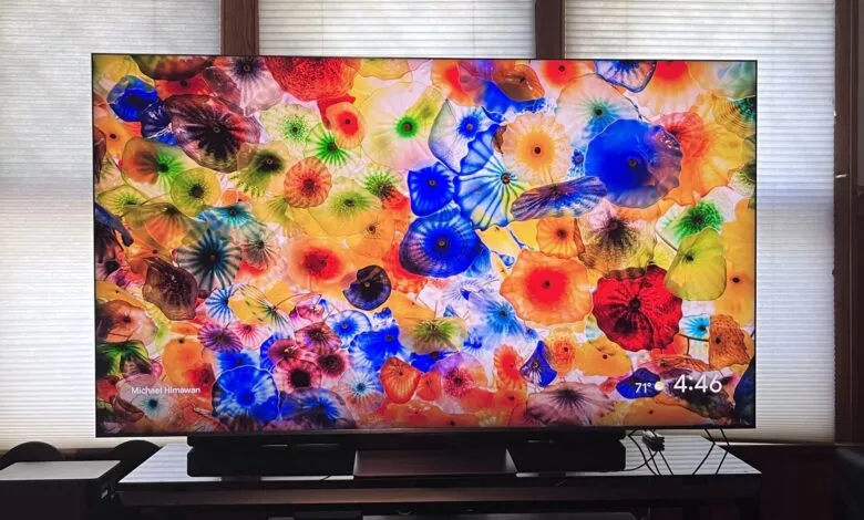 A large television screen displaying a vibrant, colorful glass art installation.