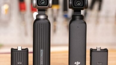 Two black DJI Osmo Action cameras with attached accessories on a wooden surface.