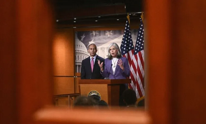 Two politicians speaking at a podium with American flags behind them.