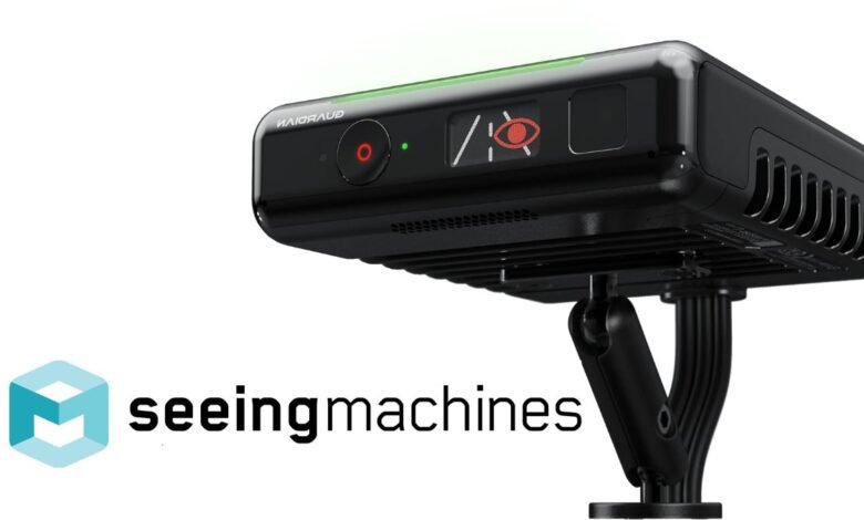 Black Seeing Machines driver monitoring system with a green light bar and eye icon.