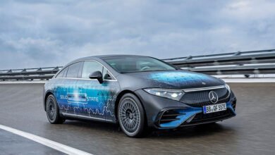Mercedes-Benz EQS prototype with 'Solid State' livery driving on a wet road.