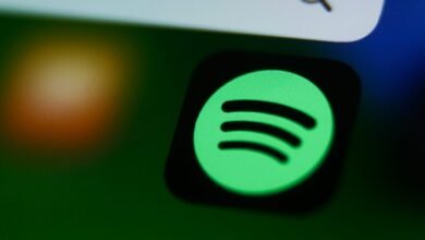 Close-up of the Spotify app icon glowing green on a dark screen.
