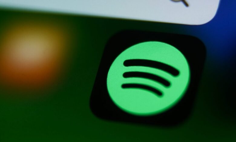 Close-up of the Spotify app icon glowing green on a dark screen.