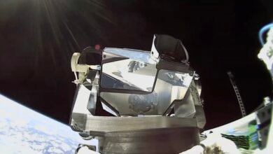 Spacecraft module with reflective surfaces against the backdrop of Earth and space.