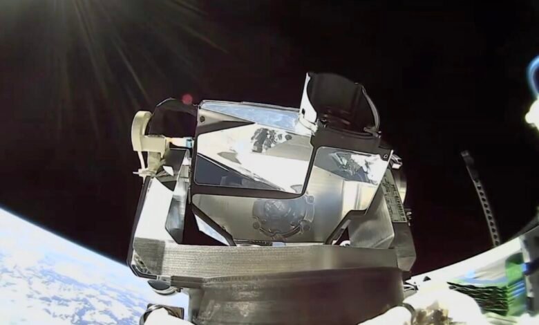Spacecraft module with reflective surfaces against the backdrop of Earth and space.