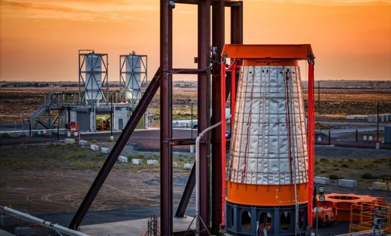 Rocket engine nozzle assembly at a launch site during sunset.