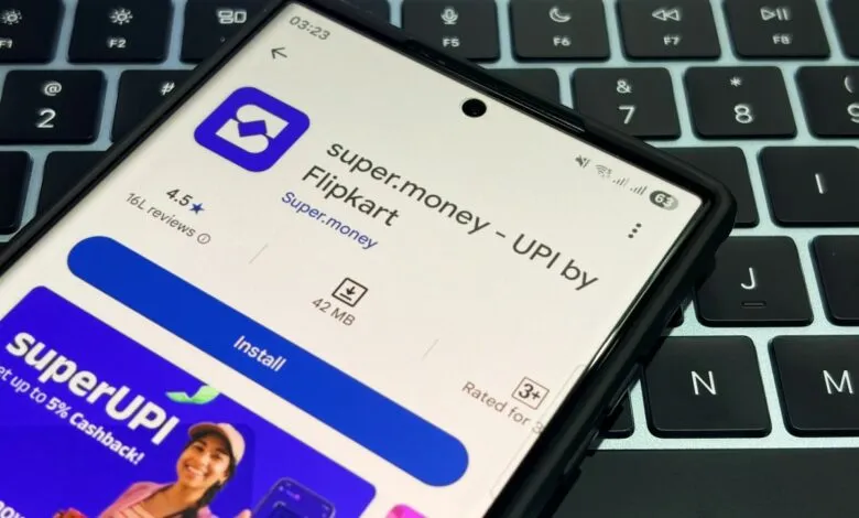 Smartphone displaying the Super.money app page on a laptop keyboard.