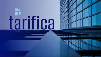 The word 'tarifica' in large blue letters with a modern building facade reflected below.