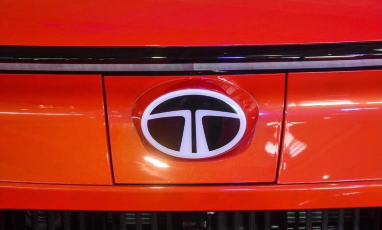 Close-up of the illuminated Tata Motors logo on an orange car.