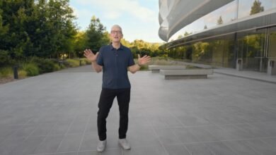 Tim Cook gestures with open hands in front of the Apple Park visitor center.